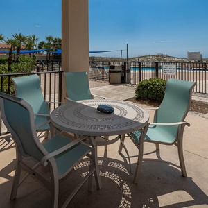 Relax on the outdoor patio overlooking the pool beach area with lush landscaping for a refreshing getaway