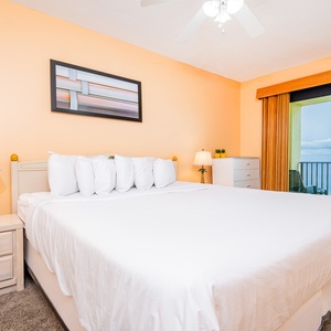 Brightly colored walls in the master complement the inviting king bed, with a balcony view and cozy seating