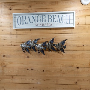 Discover charming coastal decor with a wooden wall and fish accents that welcome you to your beach getaway