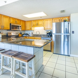 Granite counters gleam in the kitchen as you prepare a fresh brew with the coffee maker nearby