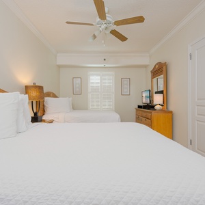 Two plush double beds and a stylish lamp, creating a cozy atmosphere in this inviting guest room