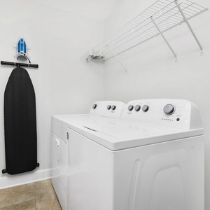 This laundry area features a convenient washer and dryer, along with a hanging rack for easy garment care