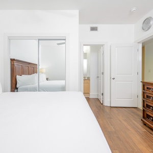 Relaxing guest bedroom featuring a cozy queen bed, elegant wooden furniture, and a flat-screen TV for your entertainment