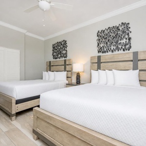 Unwind in this guest room with two cozy queen beds, soft lighting, and elegant design