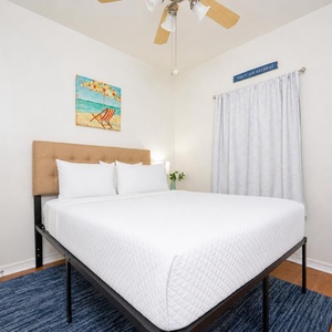 A cozy queen bed awaits in the guest suite where a fan whispers as you unwind after days of fun