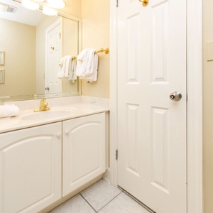Additional half bathroom for convenience with fresh towels and coastal accents