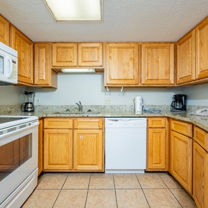 Prepare meals with ease in the spacious kitchen featuring ample counter space and white appliances
