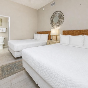Guest suite with two queens offers restful nights and a soothing bedside lamp glow for winding down