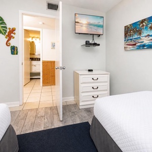 Settle in with coastal art and watch your favorite shows in this guest suite with two twin beds