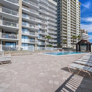 Relax by the pool surrounded by palm trees, with stunning beachfront views just steps away from your vacation rental