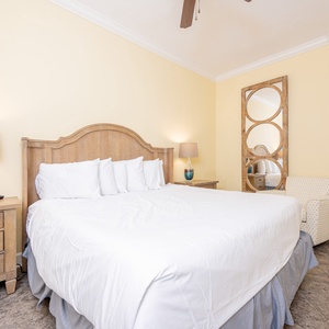 Calming guest bedroom featuring a plush king bed, stylish decor, and a cozy armchair for relaxation