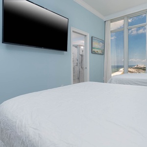 Wake to the beach in this queen guest suite with two cozy beds and unwind with a late-night show