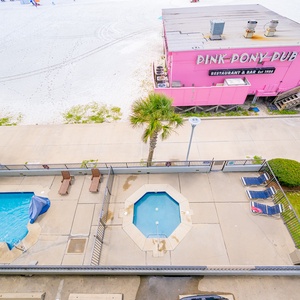 Enjoy the inviting pool area surrounded by palm trees, just steps from the beach and Pink Pony Pub