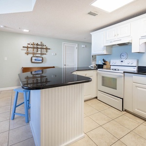 Cook meals in the stylish kitchen featuring a spacious counter, white appliances, and inviting decor for a delightful stay
