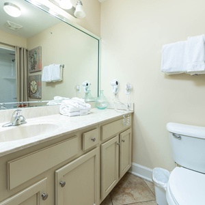 Bright and inviting guest bathroom featuring a spacious vanity, fresh towels, and a convenient tub/shower combo