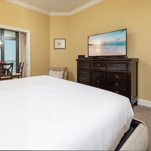 Cozy master bedroom featuring a plush king bed, a TV, and access to the dining area with a lovely view