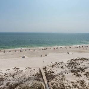 This stunning view showcases a beautiful beach with white sand and colorful umbrellas, perfect for a relaxing getaway