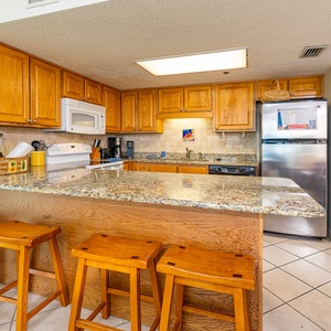 Kitchen featuring wooden cabinetry, granite countertops, and a breakfast bar with seating for a casual dining experience