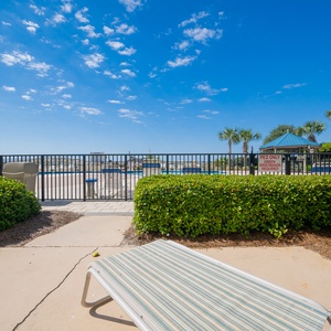 Step right from the patio into the sparkling pool area, complete with a dining table, comfortable chairs, and a relaxing chaise lounge