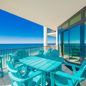 The outdoor seating area features vibrant turquoise furniture, perfect for enjoying beach views from the seventeenth floor