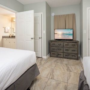 Relax in this comfortable guest bedroom featuring two cozy queen beds, a TV, and easy access to an adjoining bathroom