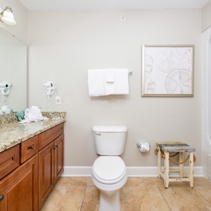 This bathroom features a stylish granite countertop, a spacious mirror, and a relaxing tub-shower combination