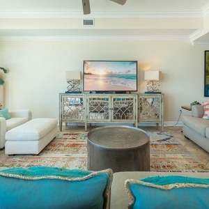 Cozy living room featuring plush seating, a large TV, and vibrant decor, perfect for relaxation and entertainment