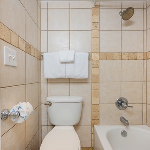 Step into the master bath where warm tile tones create a calm space to refresh after a day outdoors