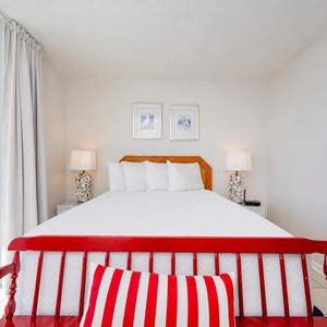 Queen master suite with plush bedding and vibrant views
