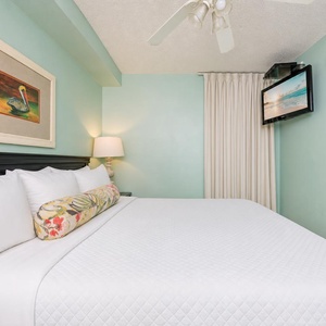 Fluffy pillows invite you to relax in the king suite for a calm movie night after a fun day at the beach