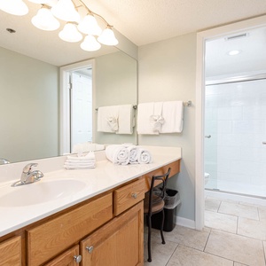 Stylish master bathroom featuring a spacious countertop, ample towels, and a refreshing walk-in shower