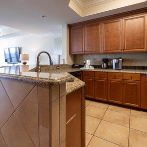 This kitchen features rich wooden cabinets, stainless appliances, granite countertops, a coffee maker and Keurig