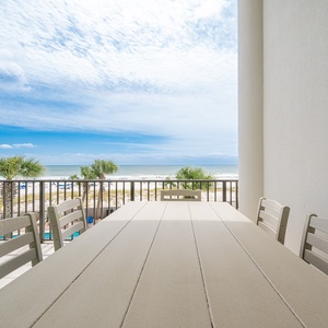 Enjoy meals on the spacious balcony with a breathtaking view of the pristine beach and vibrant blue skies