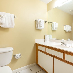 Refresh in this guest bathroom featuring a spacious vanity, ample towels, and a colorful curtain for a cheerful touch