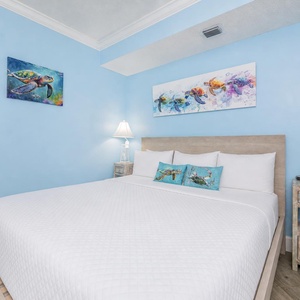 Rest in the fluffy king bed while vibrant coastal artwork adds a calming touch to this guest room