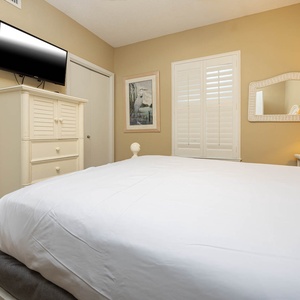 Relax in this inviting guest bedroom with a large queen bed, soft lighting, and a TV for your entertainment