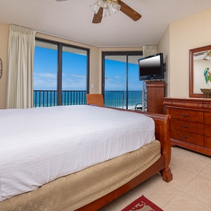 Enjoy restful nights in this inviting master bedroom with a beachfront balcony, featuring a king bed and stylish decor