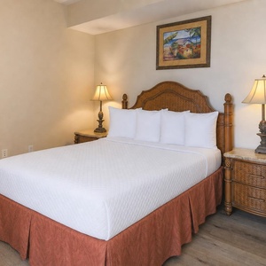 This guest bedroom features a comfortable bed, elegant lamps, and a vibrant artwork, perfect for a restful stay
