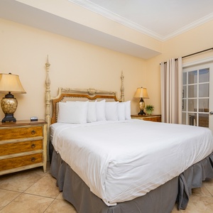The master bedroom features a king with a beautifully crafted headboard, warm lighting, and access to a scenic view