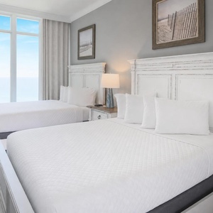 Wake to a breathtaking sunrise in this queen guest suite with two cozy beds and expansive views from the windows