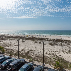This view showcases a beautiful beach front with inviting blue waters and sandy shores, perfect for relaxation and fun