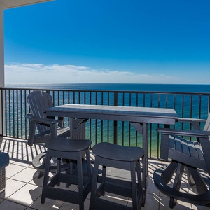 This balcony features a stylish table and chairs, perfect for enjoying stunning beachfront views