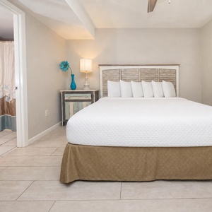 The master bedroom features a comfortable king bed, stylish decor, and an adjoining bathroom