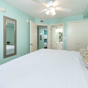 Serene bedroom suite featuring a king bed, a TV, and refreshing aqua walls that create a calming atmosphere
