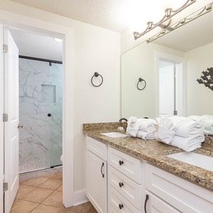 Experience a stylish master bath featuring a spacious dual vanity, elegant fixtures, and a walk-in shower for your comfort