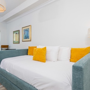 Bright and inviting room featuring a cozy twin daybed with a twin trundle, yellow accent pillows and a scenic view