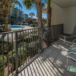 Bask in the warm sun on the balcony while enjoying views of the pool and lush landscape below