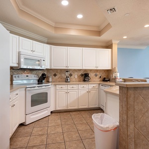 Cook your favorite dishes in the bright kitchen, where white appliances invite culinary adventures with family