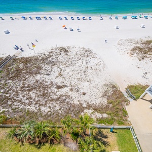 This breathtaking view showcases a serene beach with soft white sand and gentle waves, perfect for a relaxing getaway