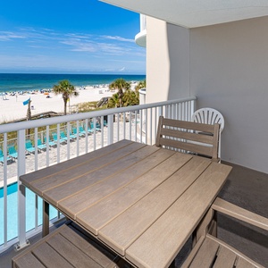 Enjoy stunning beachfront views from this balcony with a stylish dining set, perfect for relaxing meals outdoors